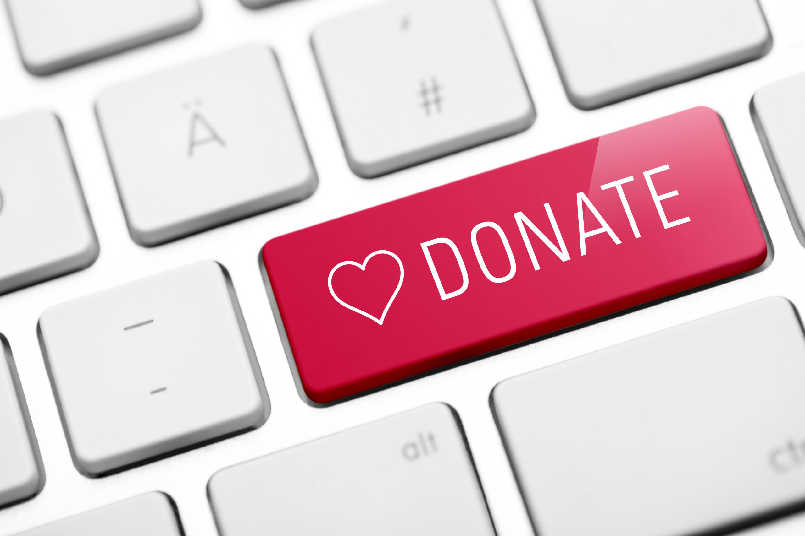 Keyboard with one red button that says donate with a heart